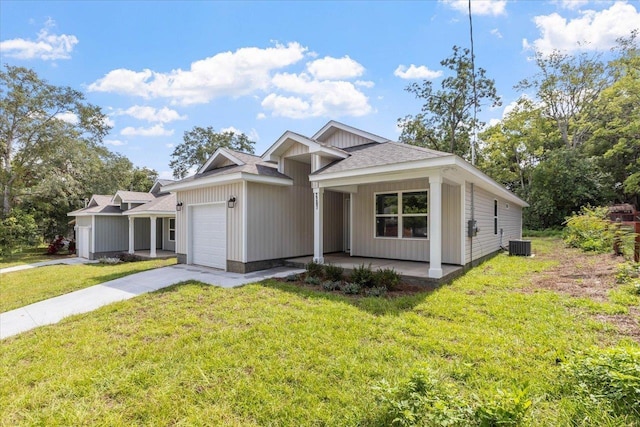 view of front of property featuring central AC unit, a garage, and a front lawn