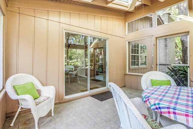 sunroom / solarium featuring a skylight and beam ceiling