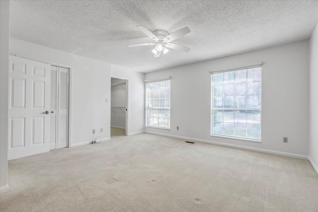 unfurnished bedroom featuring a ceiling fan, carpet, visible vents, and baseboards