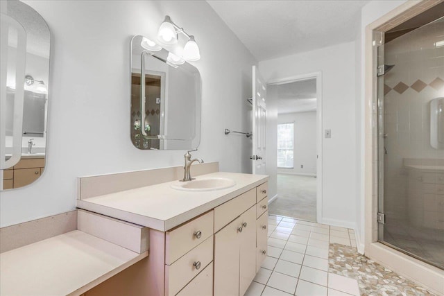 bathroom featuring a textured ceiling, a shower stall, vanity, baseboards, and tile patterned floors