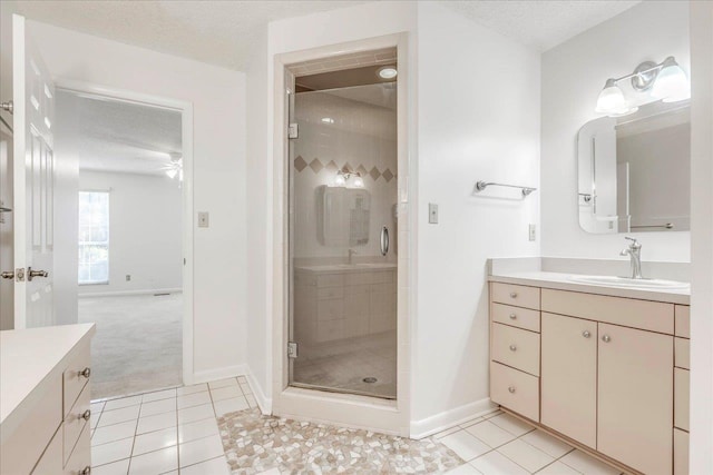 full bath featuring a stall shower, a textured ceiling, and vanity