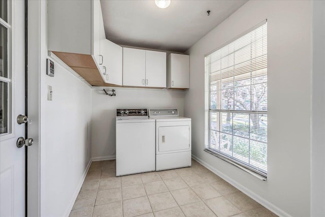 clothes washing area featuring cabinet space, light tile patterned floors, baseboards, and independent washer and dryer