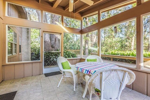 sunroom / solarium featuring a ceiling fan, wooden ceiling, and beamed ceiling