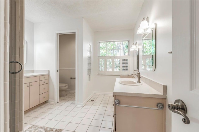 full bath featuring a textured ceiling, toilet, vanity, and tile patterned floors