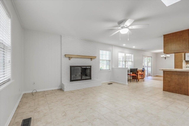 unfurnished living room with a brick fireplace, baseboards, visible vents, and a ceiling fan