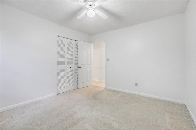 unfurnished bedroom featuring ceiling fan, a closet, carpet, and baseboards