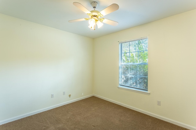 carpeted spare room featuring ceiling fan