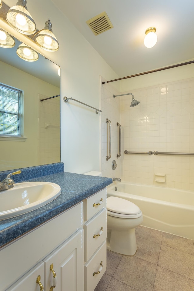 full bathroom featuring vanity, tiled shower / bath, and toilet