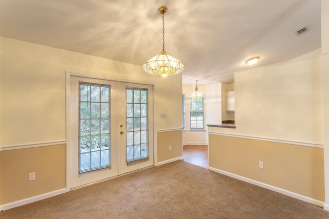 interior space with french doors, an inviting chandelier, and carpet