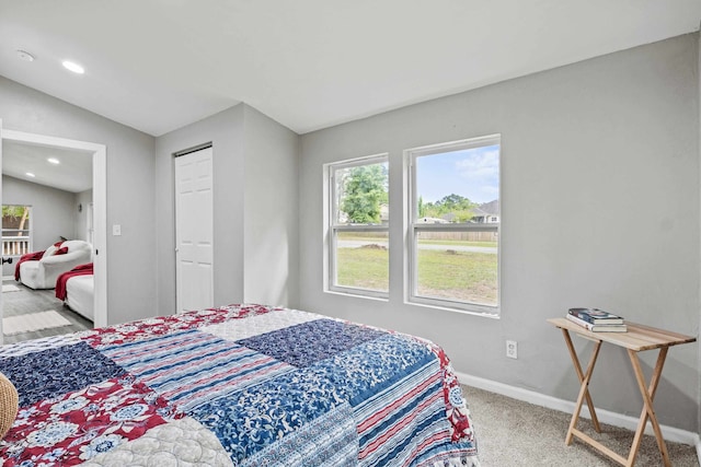 bedroom with a closet, vaulted ceiling, and carpet