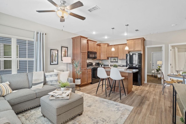 living room with ceiling fan and light wood-type flooring