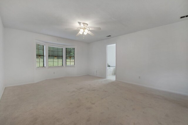 unfurnished room with ceiling fan and light colored carpet