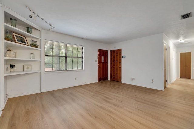 unfurnished room with light wood-type flooring and rail lighting