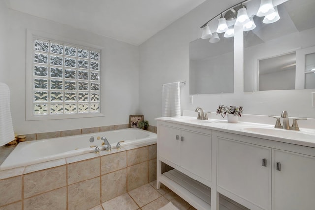 bathroom featuring a relaxing tiled tub, tile patterned flooring, vanity, and lofted ceiling