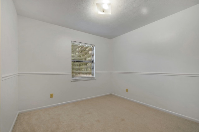 carpeted empty room with a textured ceiling