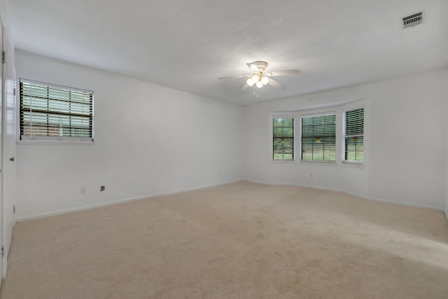 spare room featuring ceiling fan and light carpet