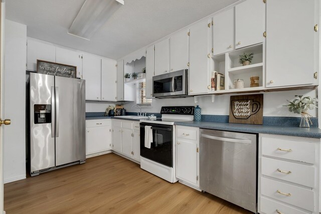 kitchen featuring white cabinetry, sink, light hardwood / wood-style floors, and stainless steel appliances