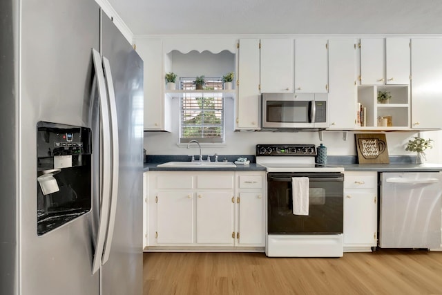 kitchen with light hardwood / wood-style floors, white cabinets, sink, crown molding, and appliances with stainless steel finishes