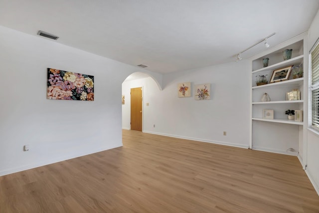 unfurnished room with track lighting and light hardwood / wood-style floors