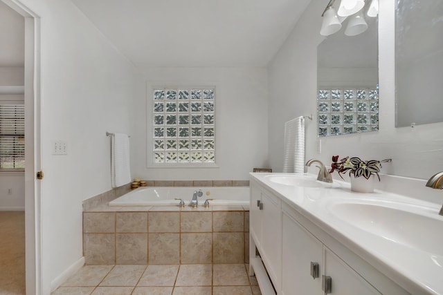 bathroom with vanity, tile patterned flooring, and tiled tub