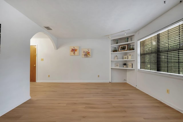 spare room with track lighting and light wood-type flooring