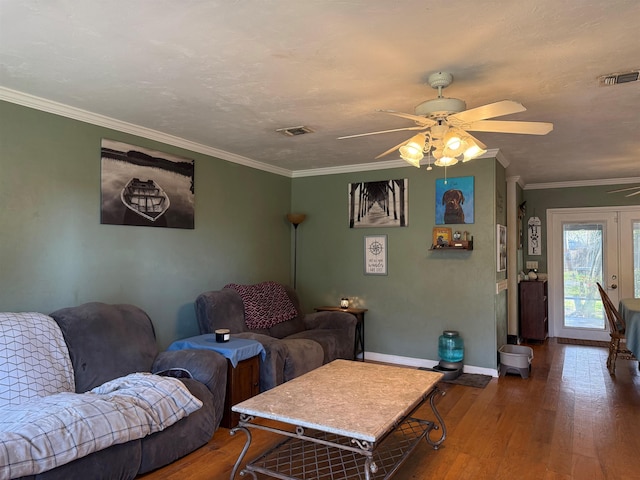 living room featuring crown molding, wood finished floors, visible vents, and baseboards