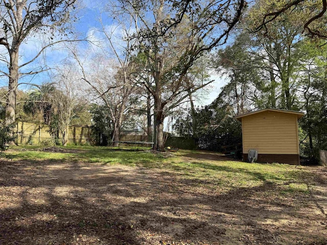 view of yard featuring a trampoline and fence