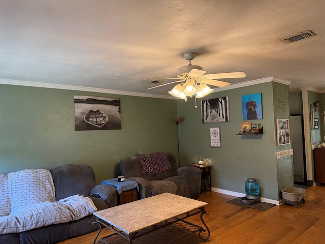 living area with a ceiling fan, wood finished floors, visible vents, and baseboards