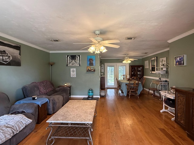 living area featuring wood finished floors, visible vents, and baseboards