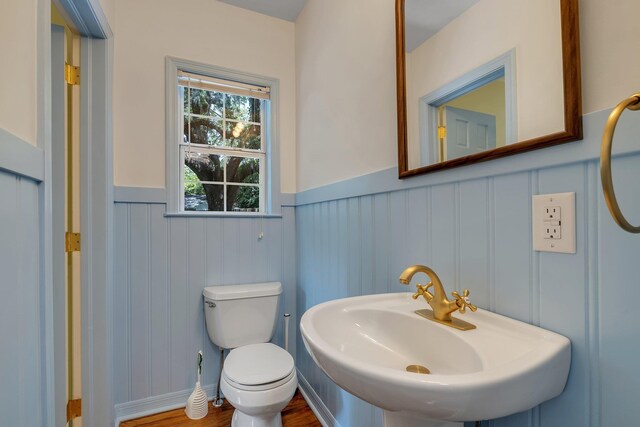 1310 E 7th Ave, Tallahassee, FL 32303 - bathroom featuring a wainscoted wall, toilet, wood finished floors, a decorative wall, and a sink