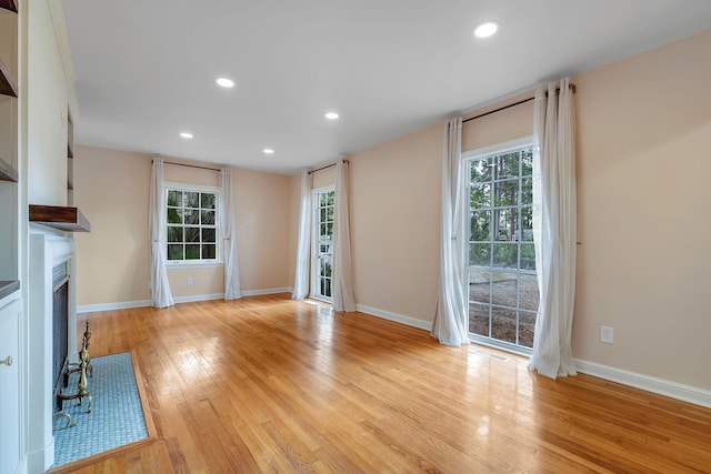 1310 E 7th Ave, Tallahassee, FL 32303 - unfurnished living room featuring light wood-style flooring, a fireplace, plenty of natural light, baseboards, and recessed lighting