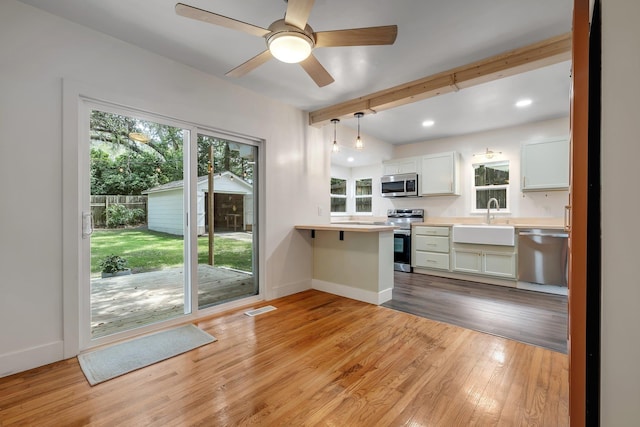 1310 E 7th Ave, Tallahassee, FL 32303 - kitchen featuring appliances with stainless steel finishes, a sink, plenty of natural light, light countertops, and beam ceiling