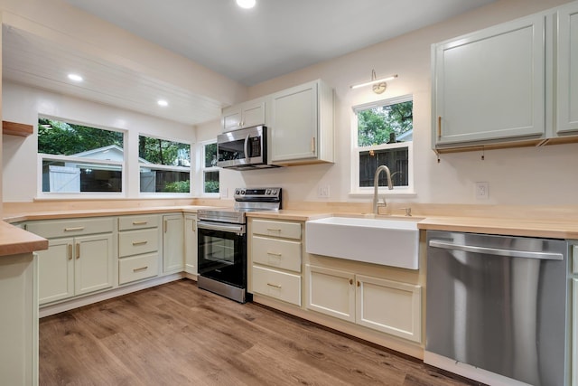 1310 E 7th Ave, Tallahassee, FL 32303 - kitchen with stainless steel appliances, a sink, light wood-style flooring, light countertops, and recessed lighting