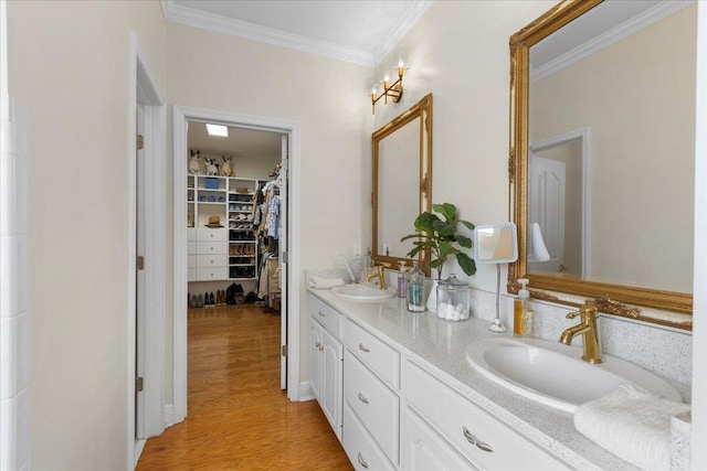 411 Worley Way, Perry, FL 32347 - bathroom with double vanity, ornamental molding, a walk in closet, and wood finished floors