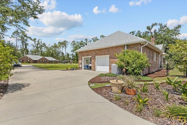 411 Worley Way, Perry, FL 32347 - view of side of home with driveway, a chimney, brick siding, and roof with shingles