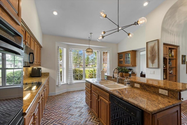 411 Worley Way, Perry, FL 32347 - kitchen with black appliances, brick patterned floors, an island with sink, brown cabinets, and vaulted ceiling