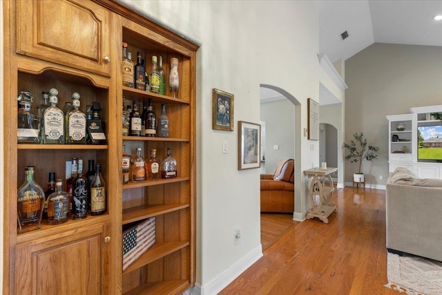 411 Worley Way, Perry, FL 32347 - bar with arched walkways, light wood finished floors, and high vaulted ceiling