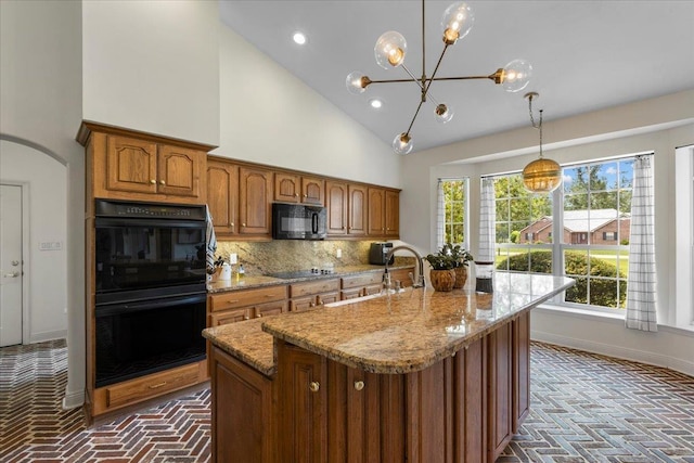 411 Worley Way, Perry, FL 32347 - kitchen with brick flooring, black appliances, brown cabinets, light stone counters, and high vaulted ceiling