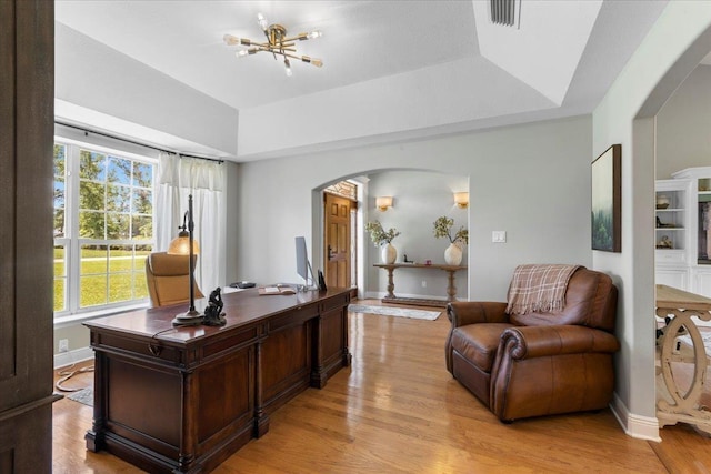411 Worley Way, Perry, FL 32347 - office featuring arched walkways, healthy amount of natural light, a tray ceiling, and light wood-style floors