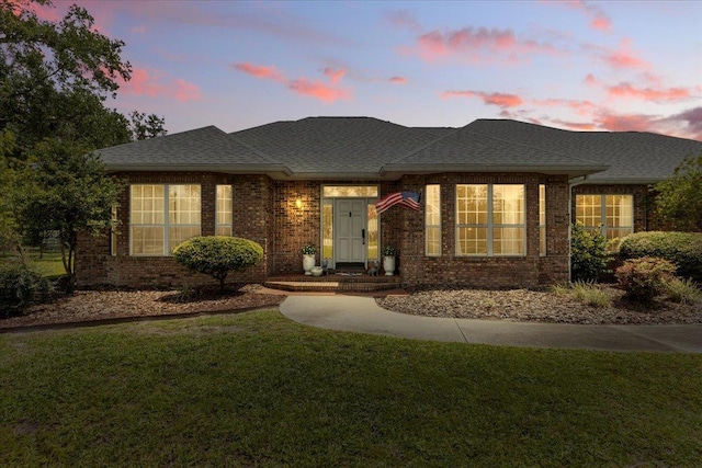 411 Worley Way, Perry, FL 32347 - view of front of house featuring a shingled roof, a front yard, and brick siding