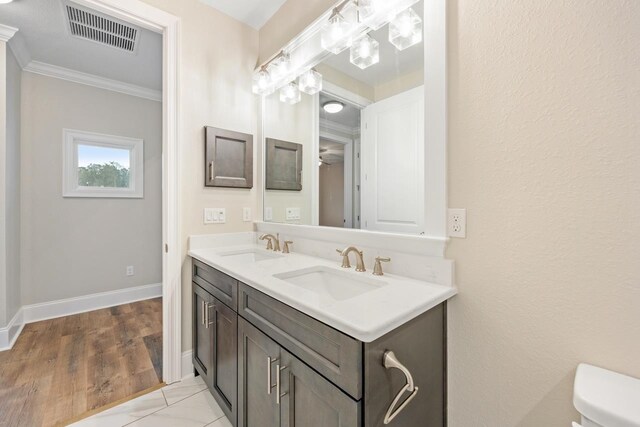 bathroom with toilet, vanity, hardwood / wood-style flooring, and crown molding