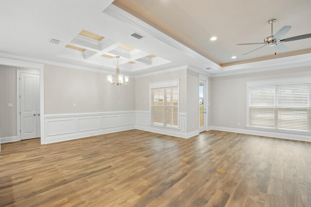 spare room featuring hardwood / wood-style flooring, beamed ceiling, ceiling fan with notable chandelier, crown molding, and coffered ceiling