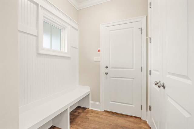 mudroom with light wood-type flooring and crown molding