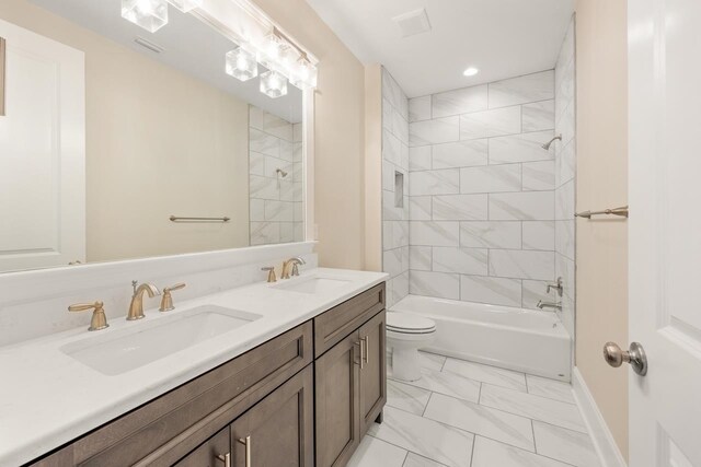 full bathroom with vanity, tiled shower / bath combo, and toilet