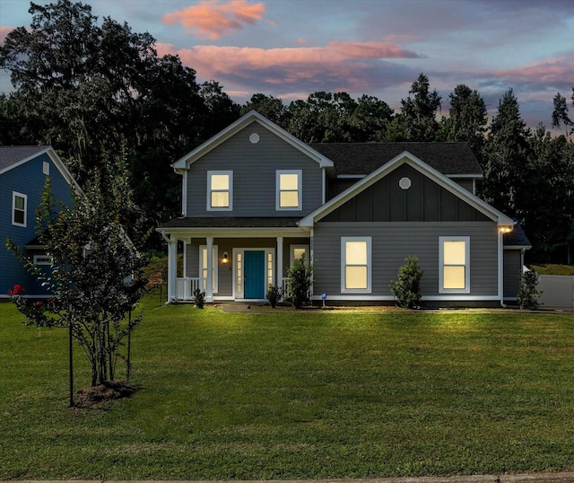 view of front of property with covered porch and a yard