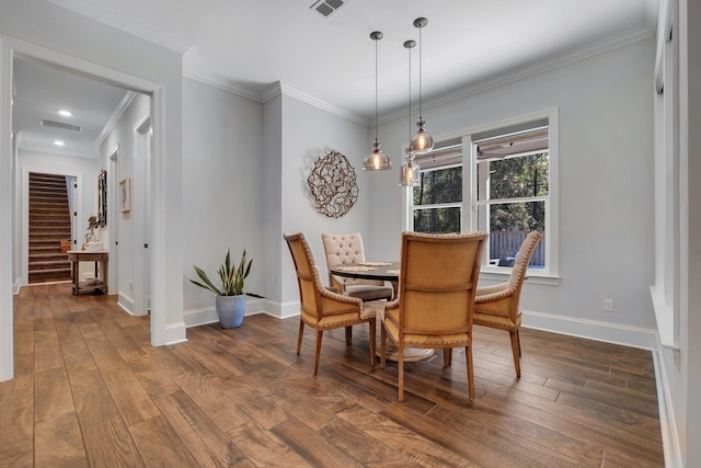 dining room featuring crown molding and dark wood-type flooring