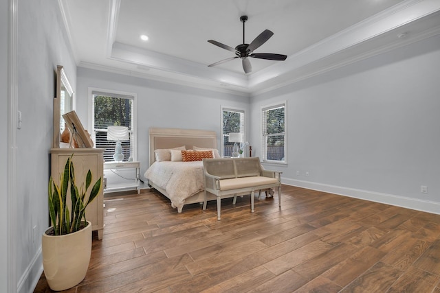 bedroom featuring crown molding, a tray ceiling, wood-type flooring, and ceiling fan