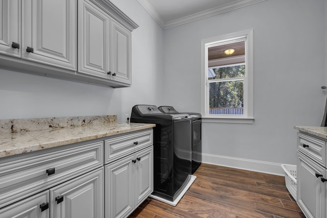 washroom with cabinets, dark wood-type flooring, ornamental molding, and independent washer and dryer