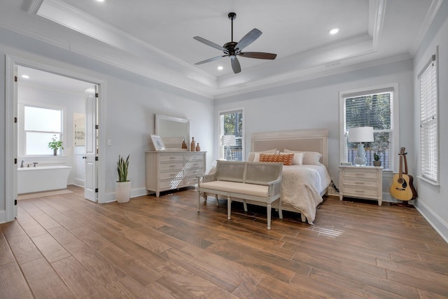 bedroom featuring crown molding, dark wood-type flooring, and a raised ceiling