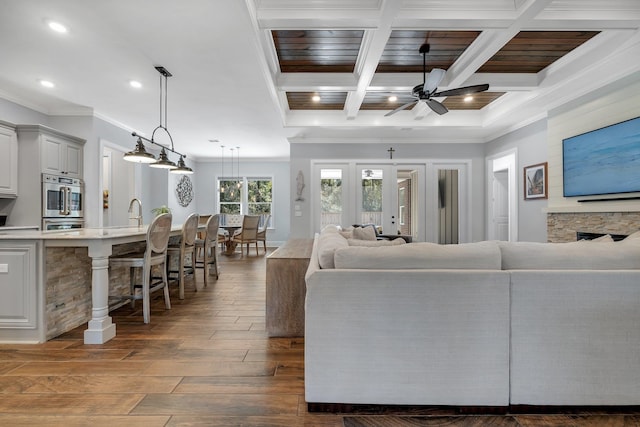 living room featuring crown molding, ceiling fan, dark hardwood / wood-style floors, coffered ceiling, and beamed ceiling